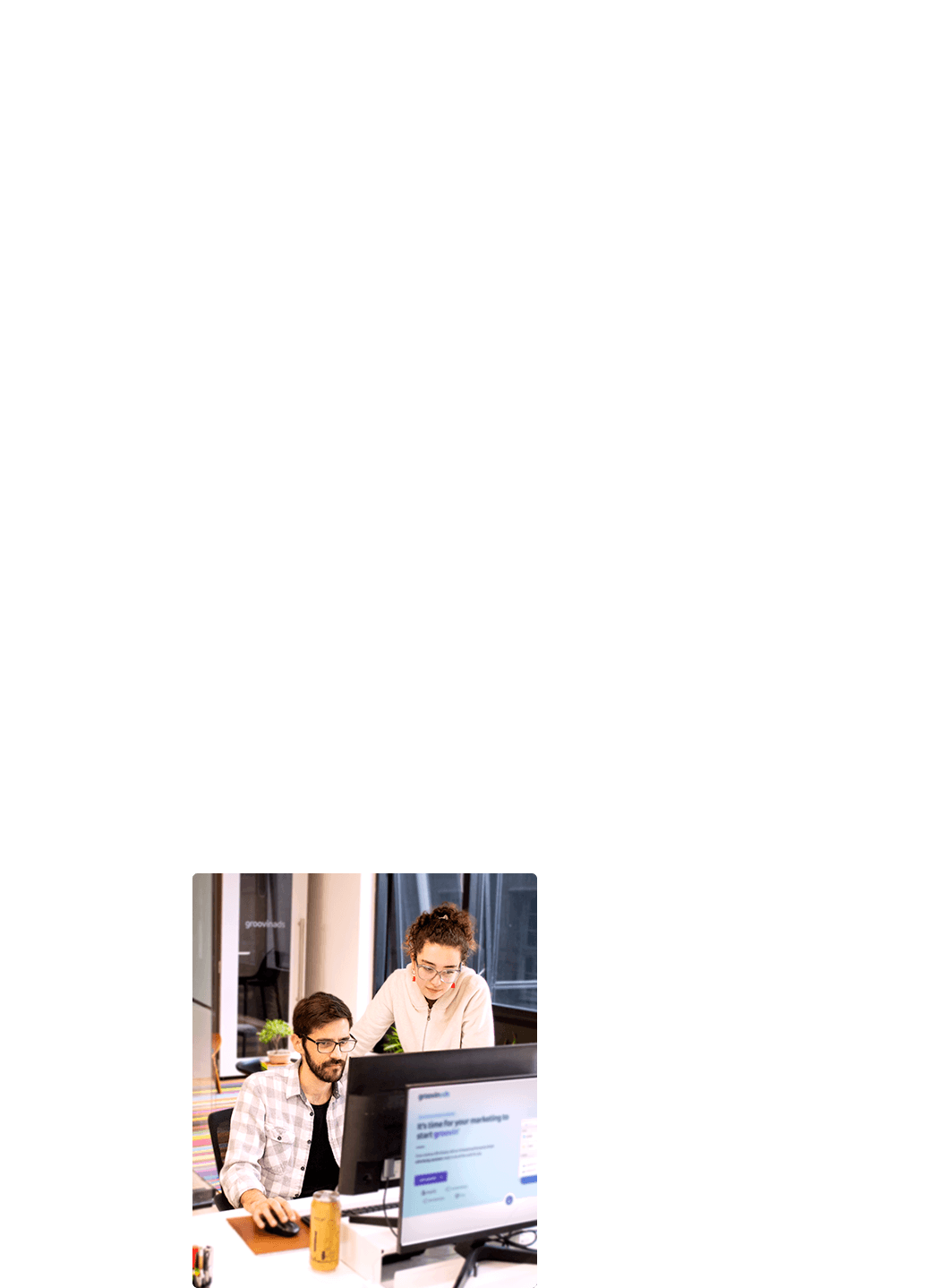 Photo of a boy working on a computer next to a girl who accompanies him